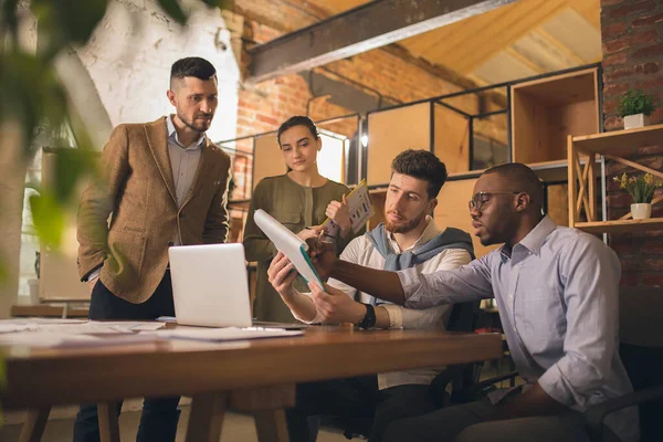 Colegas trabajando juntos en la oficina moderna utilizando dispositivos y dispositivos durante la reunión creativa — Foto de Stock