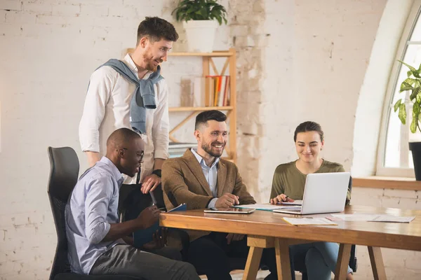 Colleghi che lavorano insieme in un ufficio moderno utilizzando dispositivi e gadget durante l'incontro creativo — Foto Stock