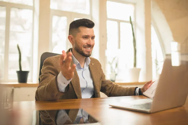 Uomo che lavora in ufficio moderno utilizzando dispositivi e gadget durante l'incontro creativo. — Foto Stock