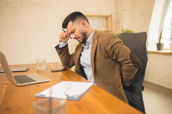 Uomo che lavora in ufficio moderno utilizzando dispositivi e gadget durante l'incontro creativo. — Foto Stock