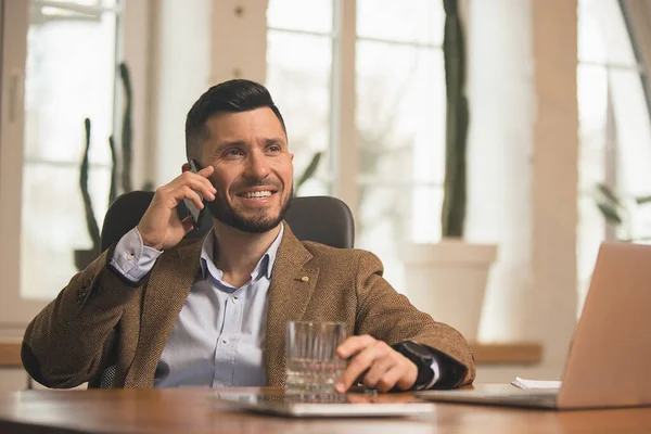 El hombre que trabaja en la oficina moderna utilizando dispositivos y aparatos durante la reunión creativa. — Foto de Stock