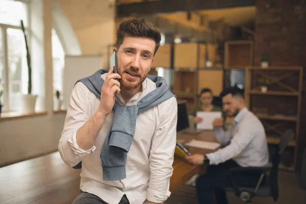 El hombre que trabaja en la oficina moderna utilizando dispositivos y aparatos durante la reunión creativa. — Foto de Stock