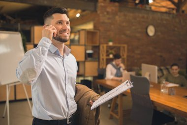 Modern ofiste çalışan bir adam yaratıcı toplantı sırasında cihazlar ve aletler kullanır..