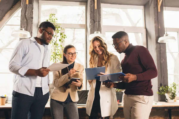 Collèges travaillant ensemble dans un bureau moderne en utilisant des appareils et des gadgets pendant les négociations — Photo