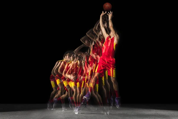 運動中の若い白人バスケットボール選手と暗い背景に混合光の中で行動。健康的なライフスタイル、プロスポーツ、趣味の概念. — ストック写真