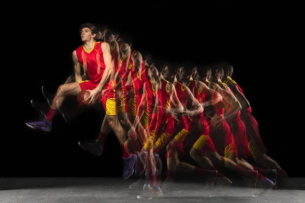 Joven jugador de baloncesto caucásico en movimiento y acción en luz mixta sobre fondo oscuro. Concepto de estilo de vida saludable, deporte profesional, hobby. —  Fotos de Stock