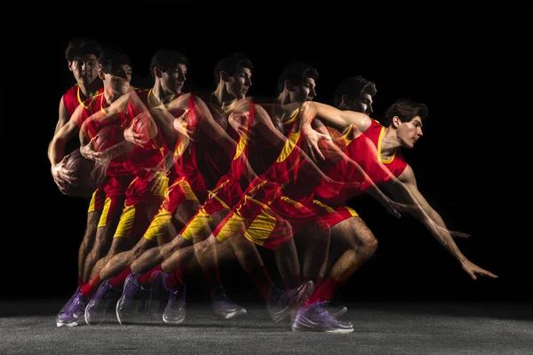 Beyaz tenli genç basketbolcu hareketli ve koyu arkaplanda karışık ışık altında hareket ediyor. Sağlıklı yaşam tarzı, profesyonel spor, hobi kavramı. — Stok fotoğraf