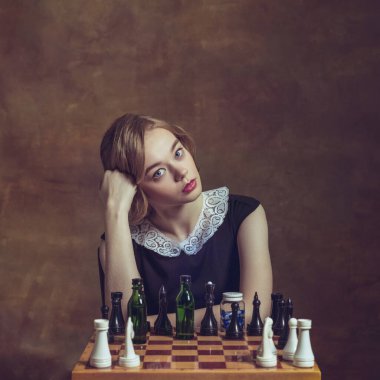 Sanat işindeki genç kadın kahverengi arka planda izole edilmiş. Retro biçimi, dönemin karşılaştırması.