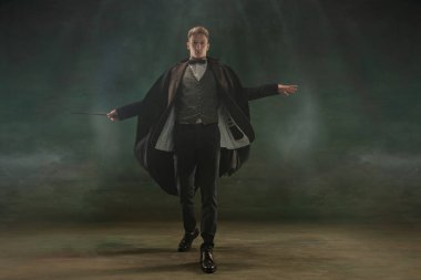 Sanattaki genç adam koyu yeşil arka planda izole edilmiş. Retro biçimi, dönemin karşılaştırması.