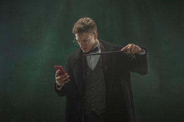 Sanattaki genç adam koyu yeşil arka planda izole edilmiş. Retro biçimi, dönemin karşılaştırması.