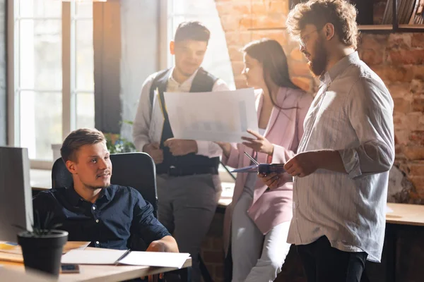 Colleghi che lavorano insieme in un ufficio moderno utilizzando dispositivi e gadget durante l'incontro creativo — Foto Stock