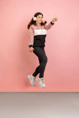 Pembe stüdyo arka planında genç kadın portresi. İnsan duyguları kavramı, yüz ifadesi, gençlik, satış, reklam.