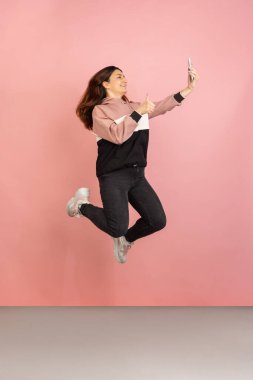 Pembe stüdyo arka planında genç kadın portresi. İnsan duyguları kavramı, yüz ifadesi, gençlik, satış, reklam.