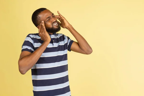 Один африканський молодий чоловік, який подає відокремлену інформацію на жовтому тлі з авторським простором для реклами. — стокове фото