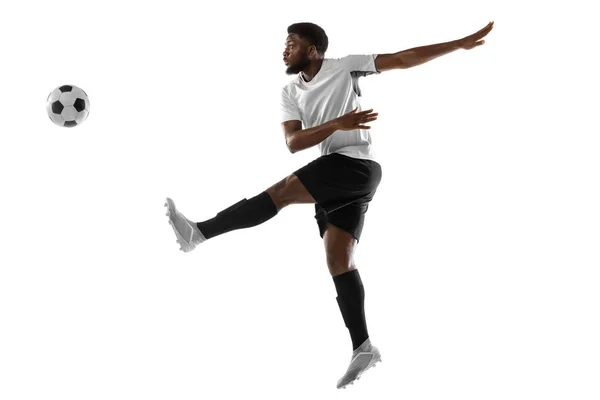 Jovem jogador de futebol africano treinando isolado em fundo branco. Conceito de esporte, movimento, energia e dinâmica. — Fotografia de Stock