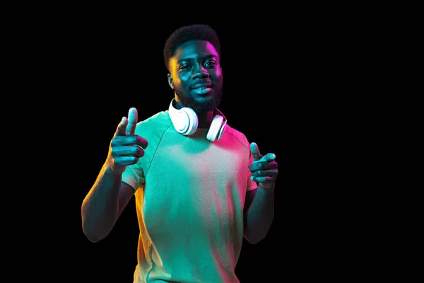 Retrato de jovens homens africanos sobre fundo escuro estúdio em néon. Conceito de emoções humanas, expressão facial, juventude, vendas, anúncio. — Fotografia de Stock