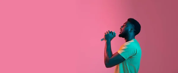 Retrato de jovens africanos em fundo de estúdio rosa em néon. Conceito de emoções humanas, expressão facial, juventude, vendas, anúncio. — Fotografia de Stock
