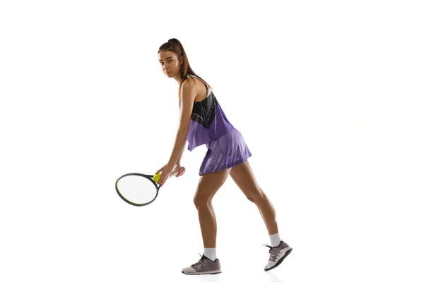 Joven mujer caucásica jugando al tenis aislado en el fondo blanco del estudio en acción y movimiento, concepto deportivo — Foto de Stock