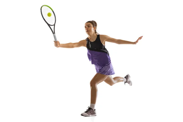 Молодая кавказская женщина, играющая в теннис на белом фоне студии в действии и движении, спортивная концепция — стоковое фото