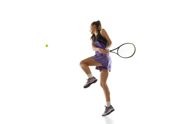Jovem caucasiana jogando tênis isolado no fundo do estúdio branco em ação e movimento, conceito de esporte — Fotografia de Stock