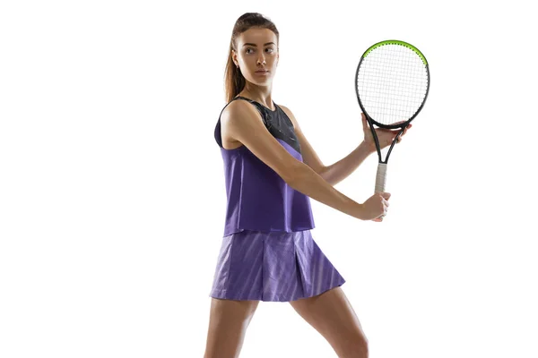 Jeune femme caucasienne jouant au tennis isolé sur fond de studio blanc en action et mouvement, concept sportif — Photo