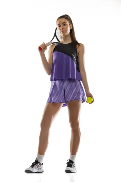 Joven mujer caucásica jugando al tenis aislado en el fondo blanco del estudio en acción y movimiento, concepto deportivo — Foto de Stock