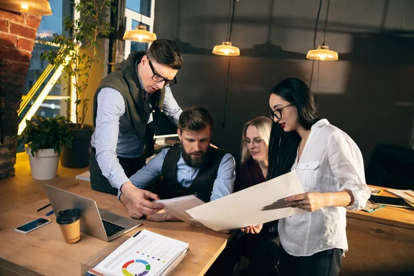 Colleghi che lavorano insieme in un ufficio moderno utilizzando dispositivi e gadget durante l'incontro creativo — Foto Stock