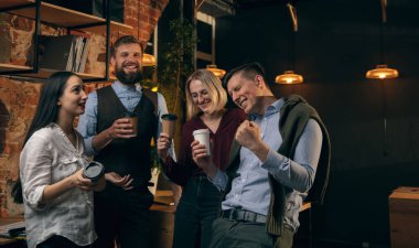 Modern ofiste birlikte çalışan meslektaşlar yaratıcı toplantı sırasında cihazlar ve aletler kullanıyorlar.