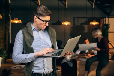 Modern ofiste çalışan bir adam yaratıcı toplantı sırasında cihazlar ve aletler kullanır.
