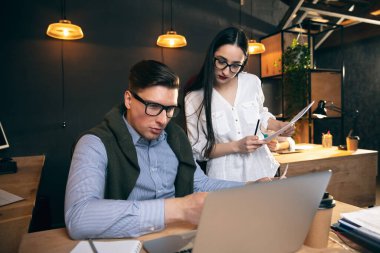 Modern ofiste birlikte çalışan meslektaşlar yaratıcı toplantı sırasında cihazlar ve aletler kullanıyorlar.