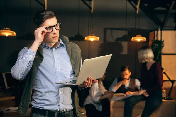 El hombre que trabaja en la oficina moderna utilizando dispositivos y aparatos durante la reunión creativa — Foto de Stock