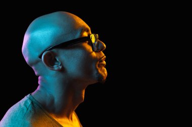 Siyah stüdyo arka planında Neon 'lu Afro-Amerikalı genç adam portresi. İnsan duyguları kavramı, yüz ifadesi, gençlik, satış, reklam.