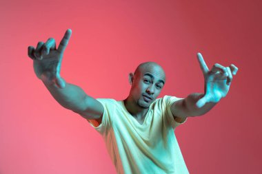 Kırmızı stüdyo arka planında Neon 'lu Afro-Amerikalı genç adam portresi. İnsan duyguları kavramı, yüz ifadesi, gençlik, satış, reklam.