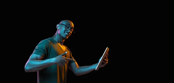 Retrato de jóvenes afroamericanos sobre fondo de estudio oscuro en neón. Concepto de emociones humanas, expresión facial, juventud, ventas, anuncio. —  Fotos de Stock