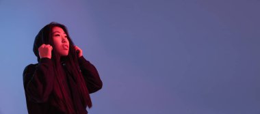 Asyalı genç bir kadının portresi neon renklerle izole edilmiş stüdyo arkaplanı. İnsan duyguları kavramı.