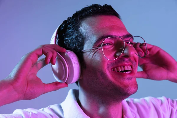 Latina unga mans porträtt på lila-blå studio bakgrund i neon. Begreppet mänskliga känslor, ansiktsuttryck, ungdom, försäljning, annons. — Stockfoto
