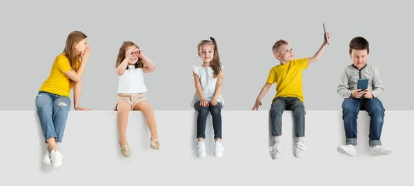 Collage de arte hecho de retratos de niños pequeños y felices aislados en el fondo del estudio blanco. Emociones humanas, concepto de expresión facial — Foto de Stock