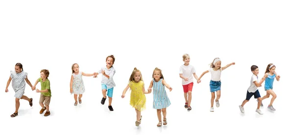 Grupa szczęśliwych dzieci szkolnych lub uczniów biegających w kolorowych ubraniach casual na białym tle studio. Kreatywny kolaż. — Zdjęcie stockowe