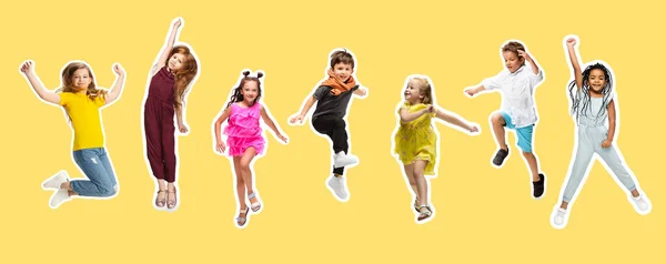 Група учнів початкової школи стрибає в різнокольоровому повсякденному одязі на жовтому тлі. Колаж . — стокове фото