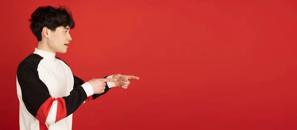 Aziatisch mans portret geïsoleerd over rode studio achtergrond met copyspace — Stockfoto