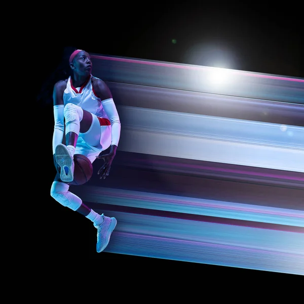 Abstract desing, concept van sport, actie, beweging in de sport. Jonge Afrikaanse vrouwelijke basketbalspeler in neon op zwarte achtergrond — Stockfoto