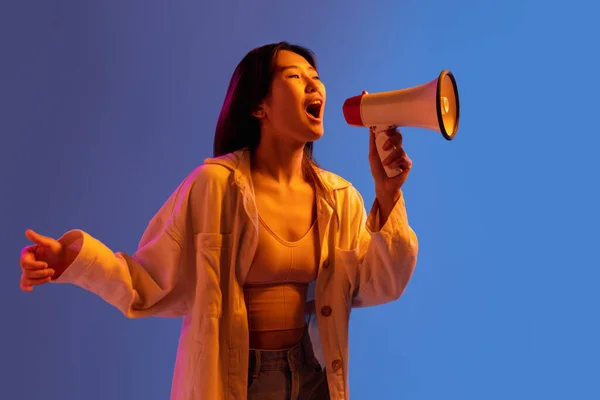 Asiatiska unga kvinnor porträtt på lutning studio bakgrund i neon. Begreppet mänskliga känslor, ansiktsuttryck, ungdom, försäljning, annons. — Stockfoto