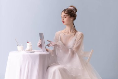 Sanat işindeki genç kadın beyaz arka planda izole edilmiş. Retro biçimi, dönemin karşılaştırması.