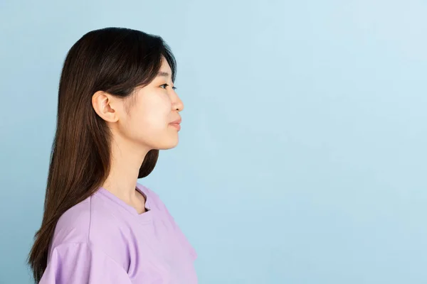 Aziatische jonge vrouwen portret op blauwe studio achtergrond. Concept van menselijke emoties, gezichtsuitdrukking, jeugd, verkoop, reclame. — Stockfoto