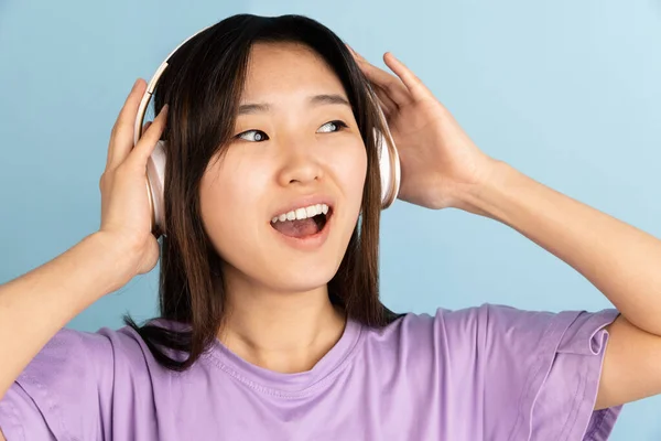 Asiatisches Porträt junger Frauen auf blauem Studiohintergrund. Konzept menschlicher Emotionen, Mimik, Jugend, Verkauf, Werbung. — Stockfoto