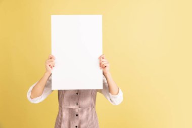 Sarı stüdyo arka planında Asyalı genç kadın portresi. İnsan duyguları kavramı, yüz ifadesi, gençlik, satış, reklam.