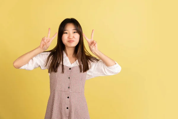 Asiatisches Porträt junger Frauen auf gelbem Studiohintergrund. Konzept menschlicher Emotionen, Mimik, Jugend, Verkauf, Werbung. — Stockfoto