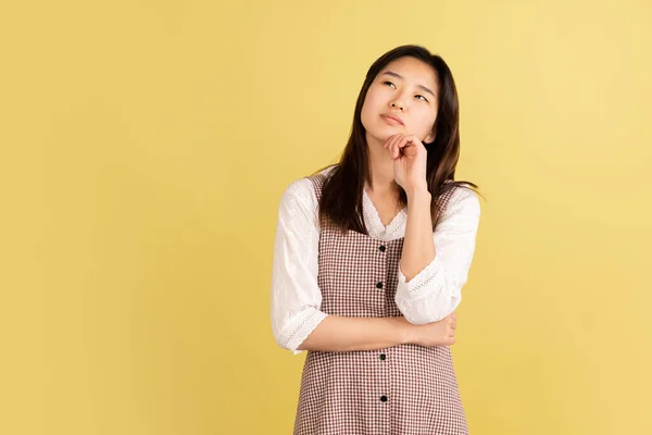 Retrato de mujeres jóvenes asiáticas sobre fondo de estudio amarillo. Concepto de emociones humanas, expresión facial, juventud, ventas, anuncio. —  Fotos de Stock