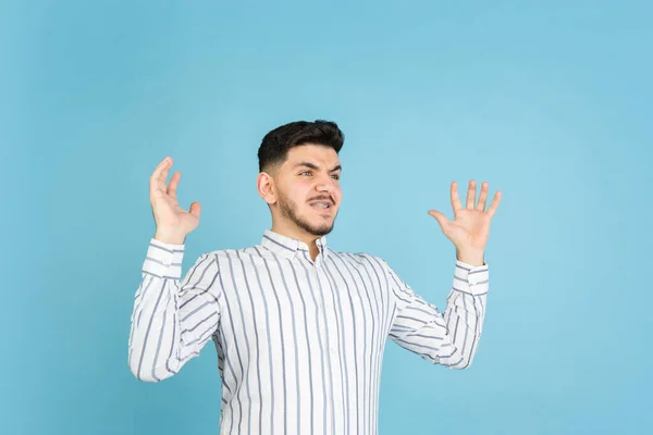 Young mans portrait on blue studio background. Concept of human emotions, facial expression, youth, sales, ad. — Stock Photo, Image