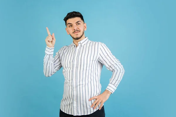 Retrato de hombre joven sobre fondo de estudio azul. Concepto de emociones humanas, expresión facial, juventud, ventas, anuncio. —  Fotos de Stock